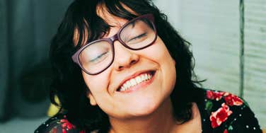 Blissfully happy woman representing independent living, self-love, and habits of single people who find joy and fulfillment on their own.