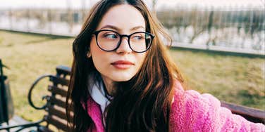 Caucasian woman in glasses reflecting outdoors, embodying simple habits that define impeccable character and accountability.
