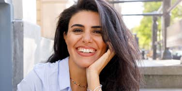 Self aware woman with her hand on her face, representing how other people teach you who you really are