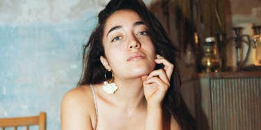 Confident woman raising an eyebrow subtly, showing quiet strength and grace while effortlessly shutting down condescending comments.