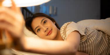 woman who loves herself turning the lights off at bedtime