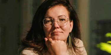 Quiet introverted woman resting her hand on her chin, showing the calm confidence and thoughtful behaviors highly respected introverts use to build strong relationships.