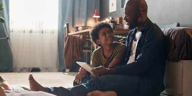 dad talking to son sitting on the floor