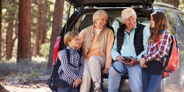 grandparents with their grandkids sitting in the back of the car