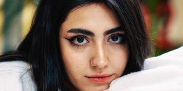 A woman’s steady gaze meets the camera — equal parts hope and curiosity — capturing the charged energy of wondering if a first date will turn into something real or fade into nothing.