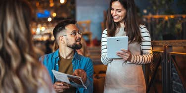 man telling waitress order at restaurant