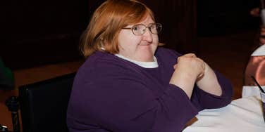 Disabled author smiling in a self-portrait, illustrating how living with a disability can make someone a more compassionate partner.