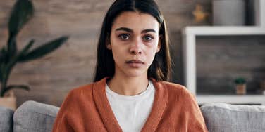 stressed woman looking concerned sitting at home