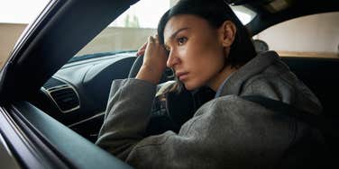 stressed out woman sitting in driver's seat of car