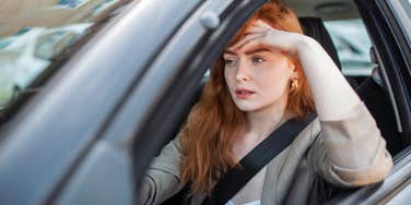 woman going through a rough time sitting in her car