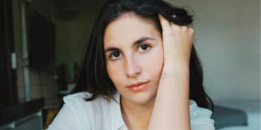 Heartbroken person with hand in their hair staring ahead showing the key emotional ingredient people lack when they can’t shake a toxic ex.