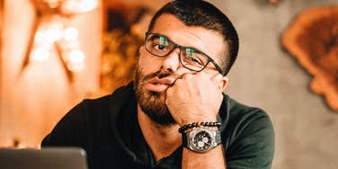 Unmotivated person staring off in boredom, embodying the habits and excuses of people who can’t stop procrastinating.