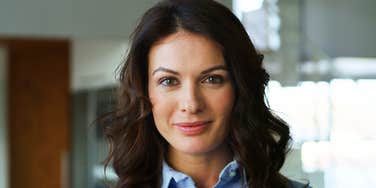 Confident professional woman smiling with purpose, embodying the energy of people who reinvent their careers later in life.