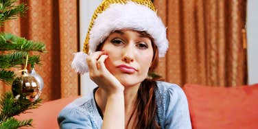 Sad woman wearing a Santa hat at Christmas, reflecting the habits that cause relationships to fall apart during the holidays.