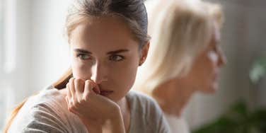 adult woman visiting her mom out of obligation and looking annoyed