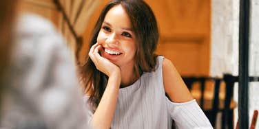 Engaging person leaning in with warm eye contact showing the science of great conversation and the habits of people everyone loves talking to.