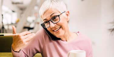 Warm parent happily talking on the phone with an adult child showing the simple habits of parents whose grown kids actually want to call them.