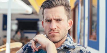 man looking unfriendly sitting outside