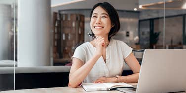 smiling young woman working on laptop at work