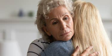 sad older woman hugging adult daughter