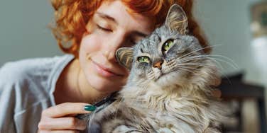 woman cuddling up to guardian spirit cat