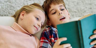little boy and little girl reading a book together