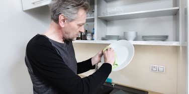 widower who is annoyed because he has to do the dishes himself