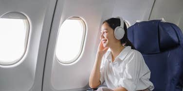 woman sitting in the window seat on a plane