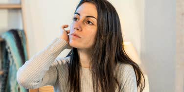 You’ll Know You’re Ready To Change Your Life When These Soft Things Start Happening Woman at home workspace thinking deeply, showing the quiet, subtle moments that indicate she’s ready to make meaningful changes in her life.