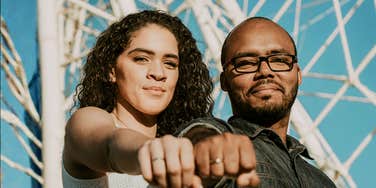 confident driven couple standing side by side with fists forward, symbolizing the simple signs you’ve found a high-achieving soulmate and are truly a power couple