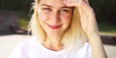 Smiling woman on a city street in casual clothes, meeting the camera with quiet confidence, capturing the moment you finally decide to make moves in your life.