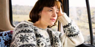 Thoughtful woman staring out a window during a quiet moment showing the art of the reset and the steps to take when life feels out of control.