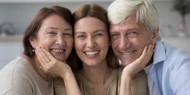 happy woman smiling with her baby boomer parents