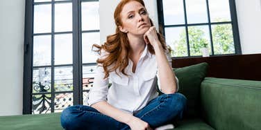 wealthy woman who grew up with money sitting on her couch