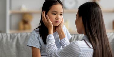 Young mother comforting her sad daughter