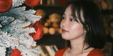 Woman puts up holiday decor.