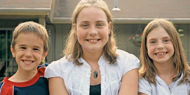 90s kids siblings smiling playing outside