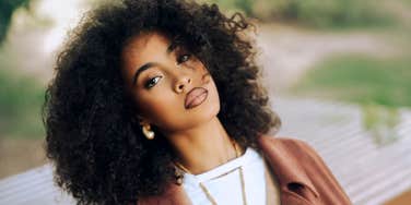 Habits Of Women That Indicate High-Level Charisma confident charismatic woman holding relaxed eye contact and natural presence, illustrating the subtle everyday habits that signal high-level charisma