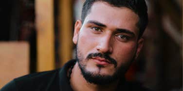 Man with a guilty distant expression, illustrating the signs a man is probably going to cheat on you again.