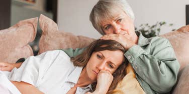 older parent worried about losing adult daughter laying on her
