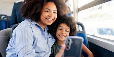 mom taking a selfie with her son on the bus