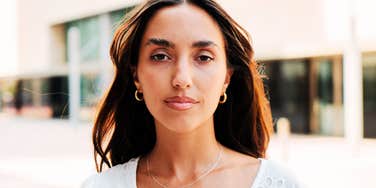 person displaying defensive body language and accusatory expression, reflecting a tendency to cast others as the villain