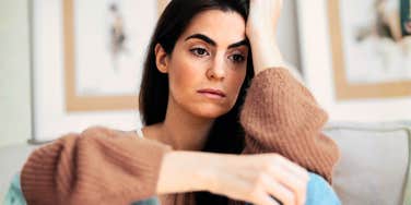 Woman sitting alone with a tired, resigned expression, illustrating the emotional weight of staying in a lopsided relationship.