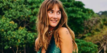 Thoughtful shy introverted woman smiling softly in nature, illustrating how highly introverted minds perceive things in ways that totally confuse others.