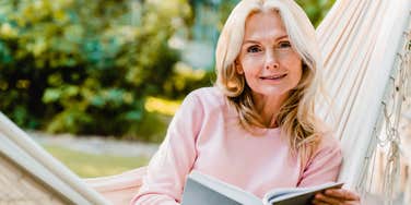 older woman reading a book ignoring her phone