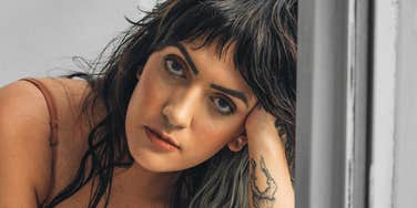 Person resting their head on their hand showing the subtle habits of people who secretly don’t want to be in a relationship