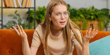 annoyed woman with her hands up feeling disrespected at home