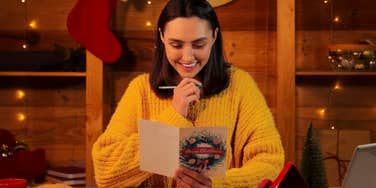 happy festive woman writing holiday cards