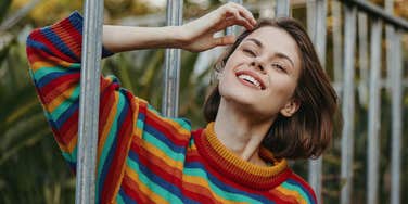 woman who thinks smarter and faster smiling on railing