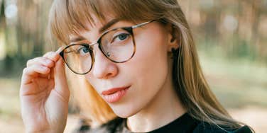 highly analytical woman touching her glasses